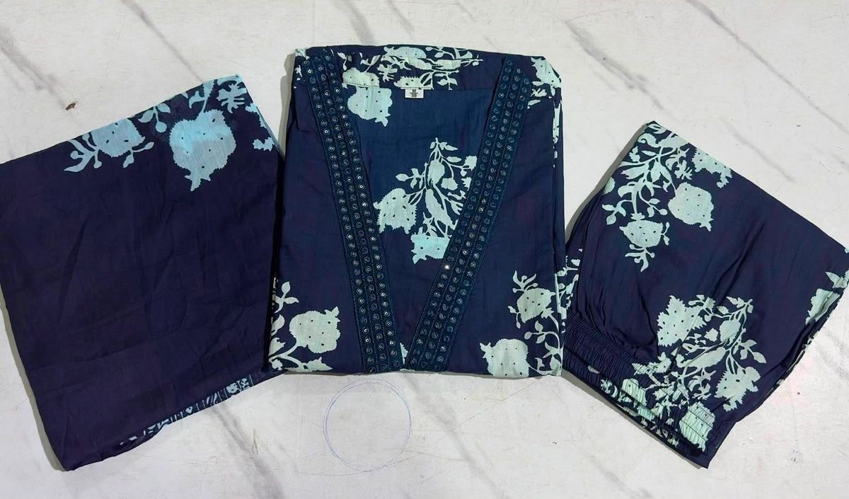 A folded navy blue fabric garment set with a light blue floral print, laid flat on a white marble surface. The set includes a central folded piece with decorative trim and two matching side pieces.